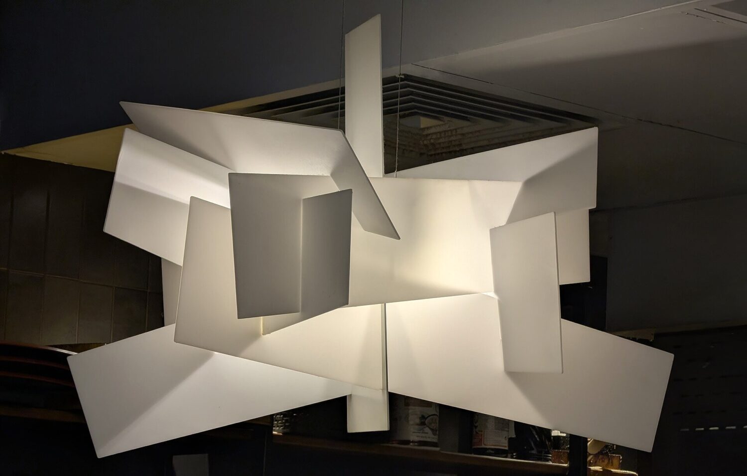 Geometryczna biała lampa wisząca w salonie
